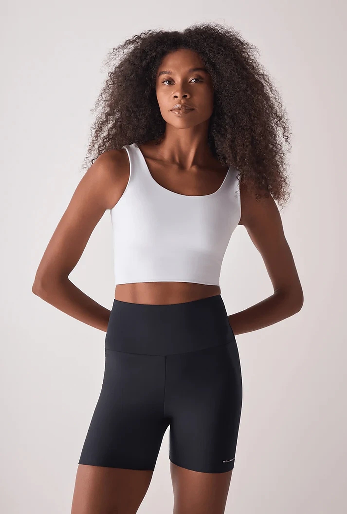Modelo com top branco e bermuda preta da linha Soft