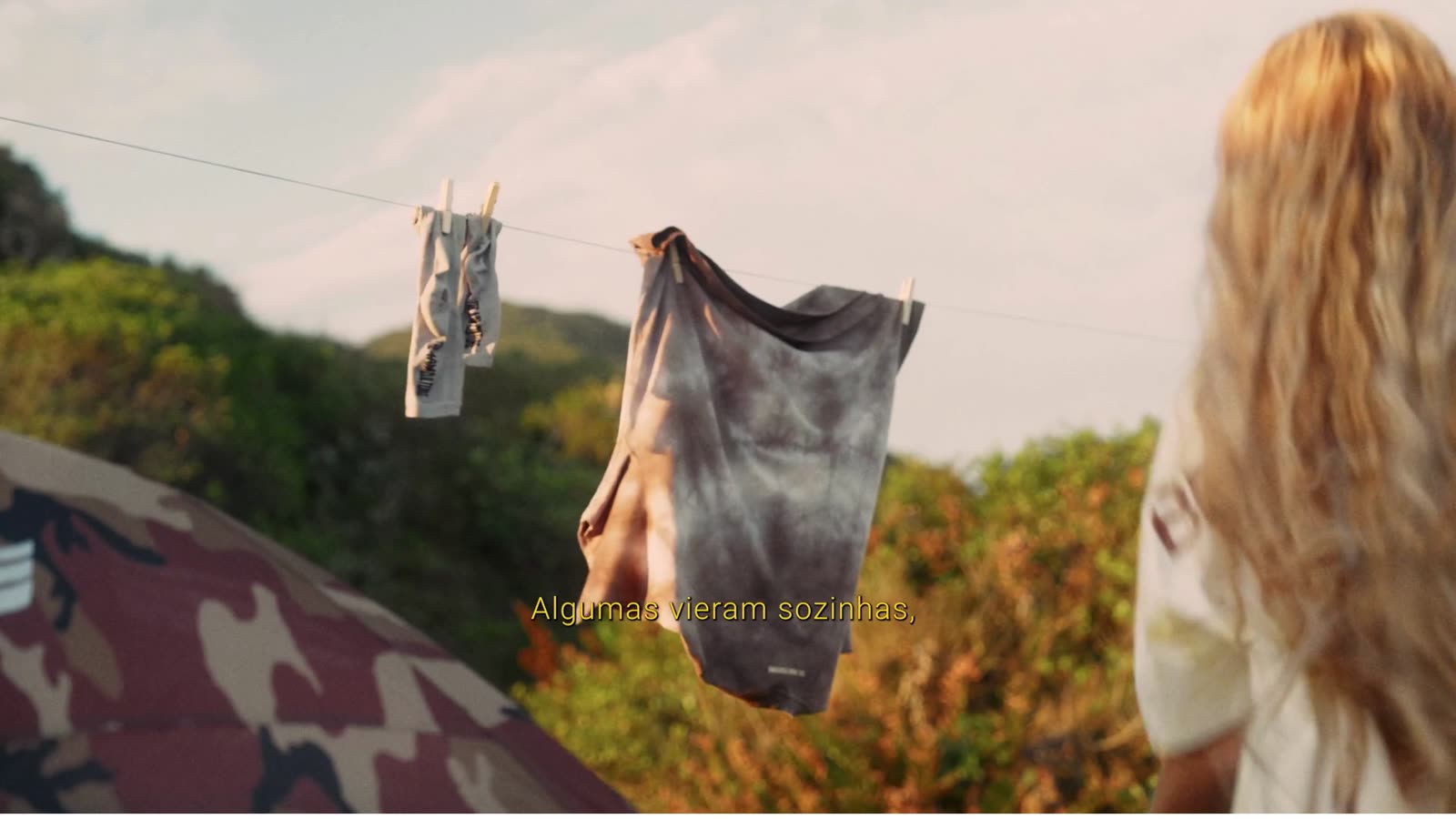 Roupas no varal ao lado da barraca: “Algumas vieram sozinhas.”